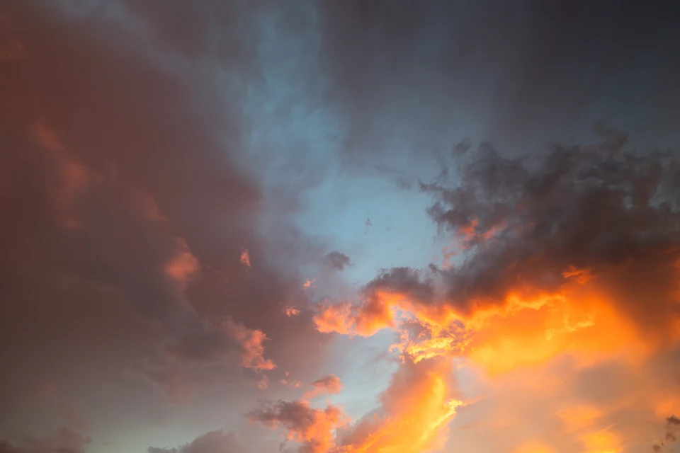 Orange light catches the edge of dark blue and gray storm clouds.
