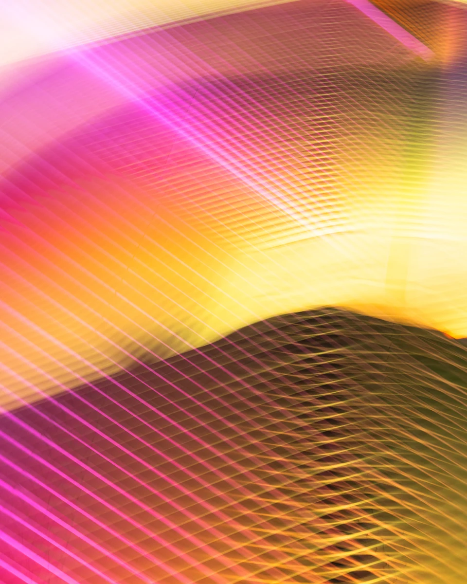 Sweeping pink and golden bands of light overlap a fine architectural grid.